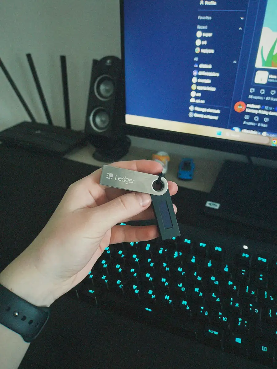 Hand holding Ledger hardware wallet